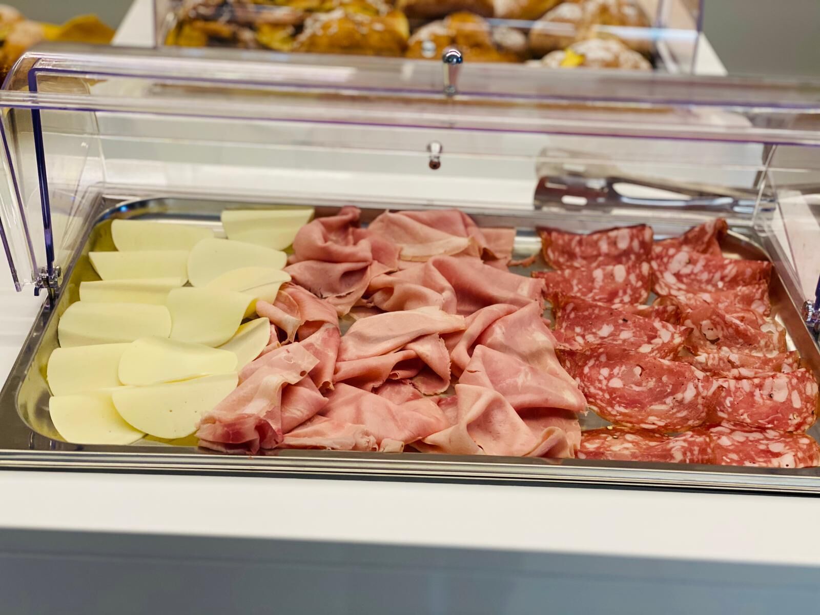 Buffet com presunto fatiado, salame e queijo.