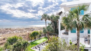 A coastal property with a golf course, a white building with blue windows, and a view of the beach. - 129 Dune Lane- Welcome to 5,000 square feet of oceanfront bliss! (Hilton Head Island)