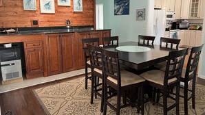 A kitchen with wooden cabinets, a dining table with chairs, and artwork on the walls. - CANAL FRONT - GREAT VIEWS - 5 BDRM, 3&1/2 BATHS, 2 KINGS, GOLF, RELAX... (Ocean Pines)
