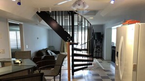A modern kitchen with a white refrigerator, a dining area with a glass table and chairs, and a staircase leading to an upper level. - CANAL FRONT - GREAT VIEWS - 5 BDRM, 3&1/2 BATHS, 2 KINGS, GOLF, RELAX... (Ocean Pines)