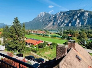 Surrounded by a picturesque mountain backdrop, this scenic area offers a tranquil setting with access to a green field for outdoor activities.