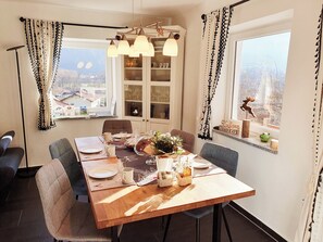 Enjoy meals in this dining area with a table for four, surrounded by a chandelier and a view of the city.