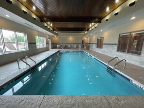 An indoor swimming pool with clear water, metal railings, and a wooden ceiling. - Holiday Inn Express & Suites Ft. Smith Airport by IHG (Fort Smith)