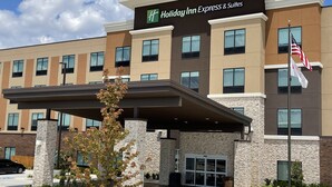 A Holiday Inn Express & Suites building with a modern design, featuring a stone facade, multiple windows, and a covered entrance. - Holiday Inn Express & Suites Ft. Smith Airport by IHG (Fort Smith)