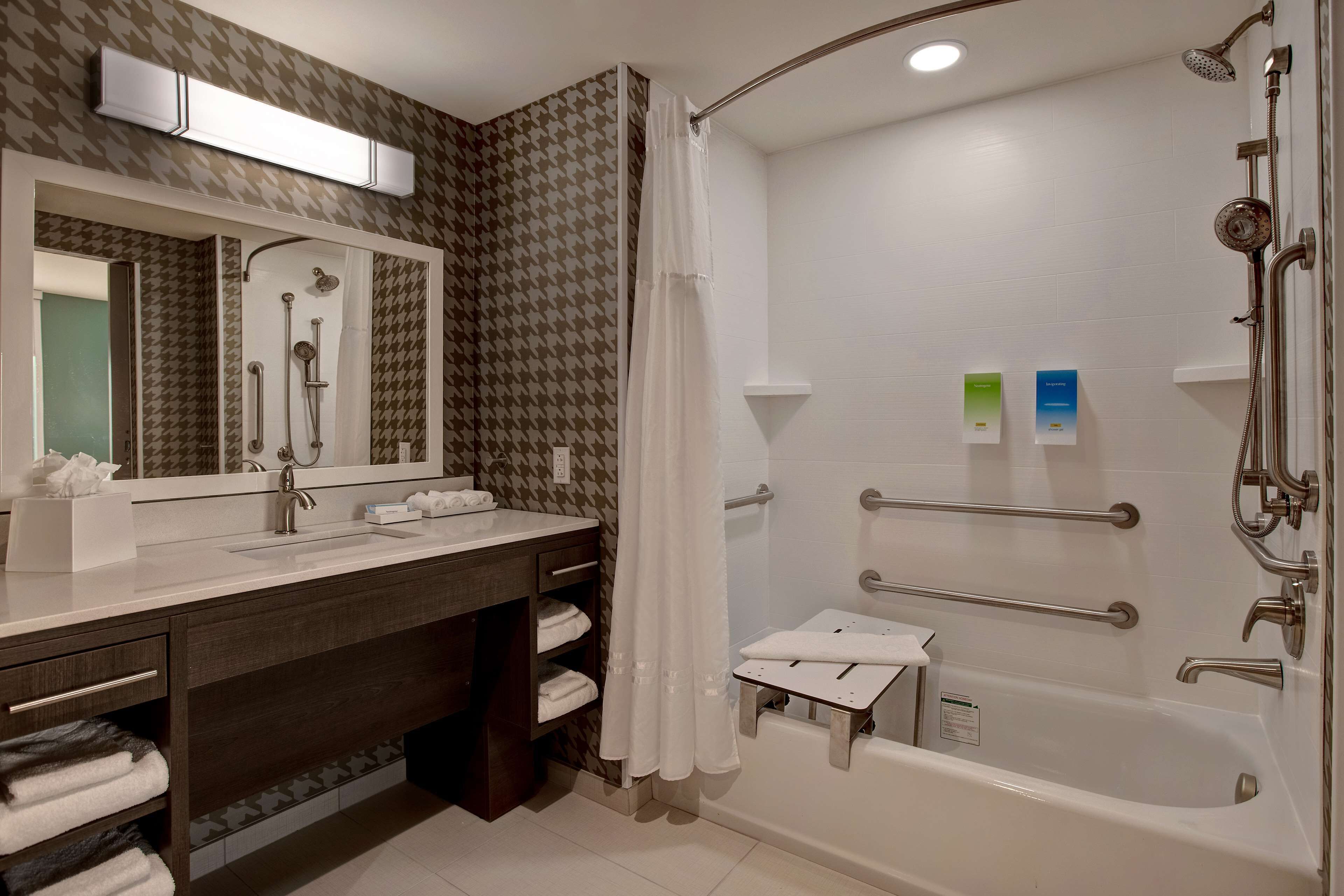 Une salle de bain moderne équipée d’une douche, d’un lavabo, d’un miroir et d’un meuble-lavabo.