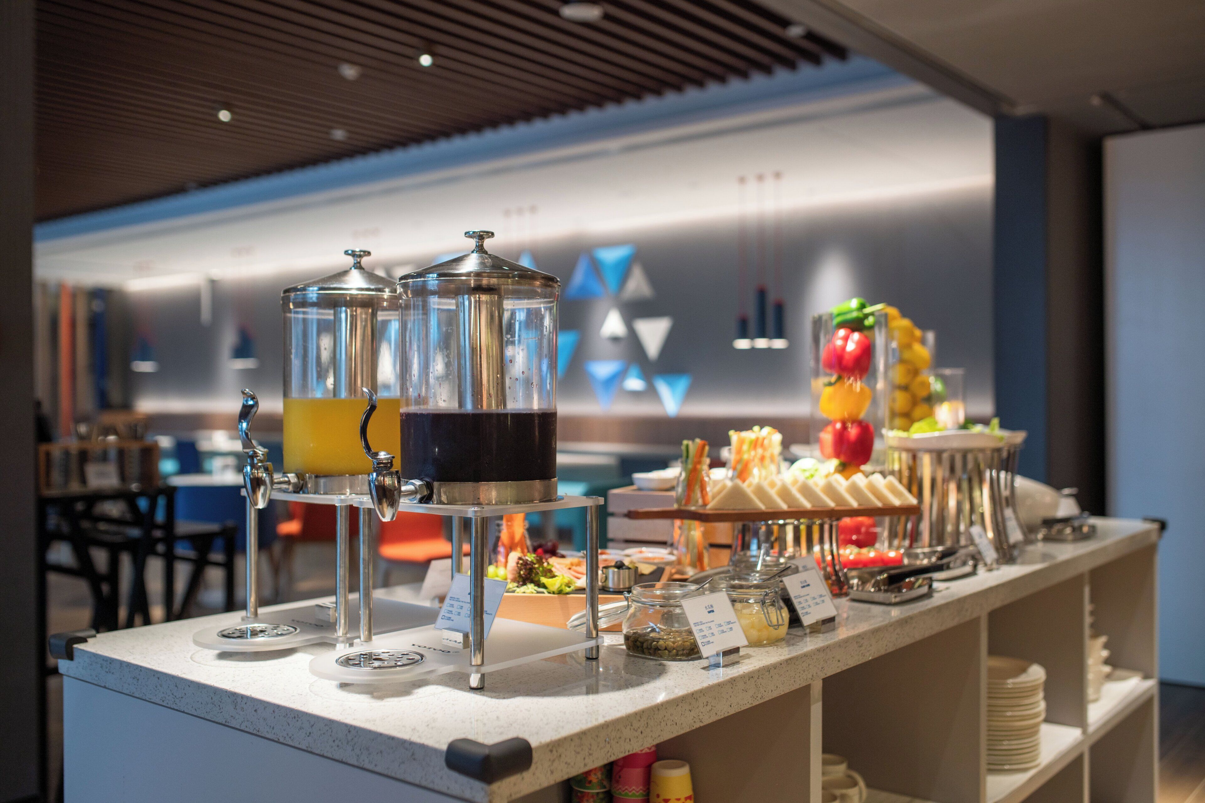 A buffet setup with various food items and drink dispensers.