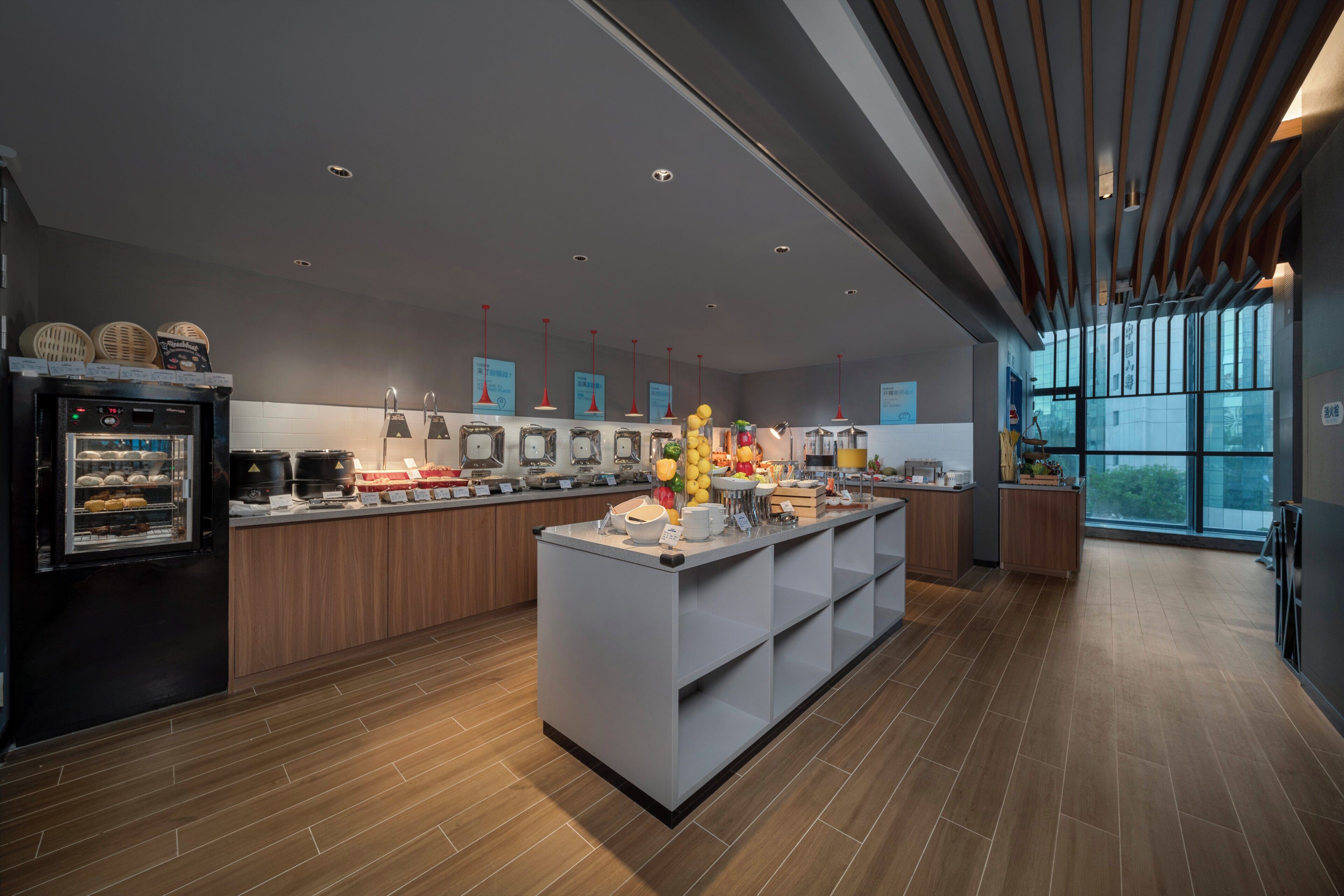 A modern kitchen with a central island, built-in appliances, and a large window providing natural light.
