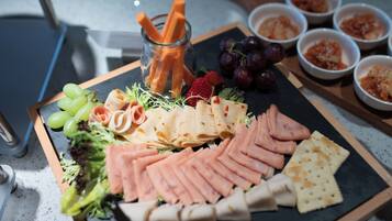 A charcuterie board with various meats, cheeses, and fruits.