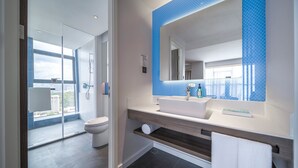 A modern bathroom with a large mirror, white sink, and a glass shower enclosure. - Holiday Inn Express Zhuhai Gongbei by IHG (Zhuhai)