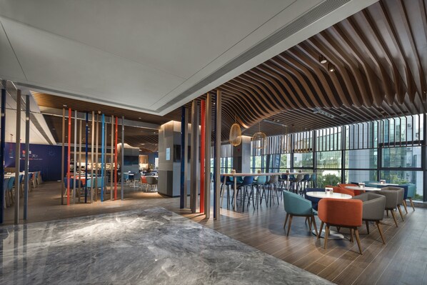 A modern interior with a mix of seating areas, large windows, and a unique ceiling design. - Holiday Inn Express Zhuhai Gongbei by IHG (Zhuhai)