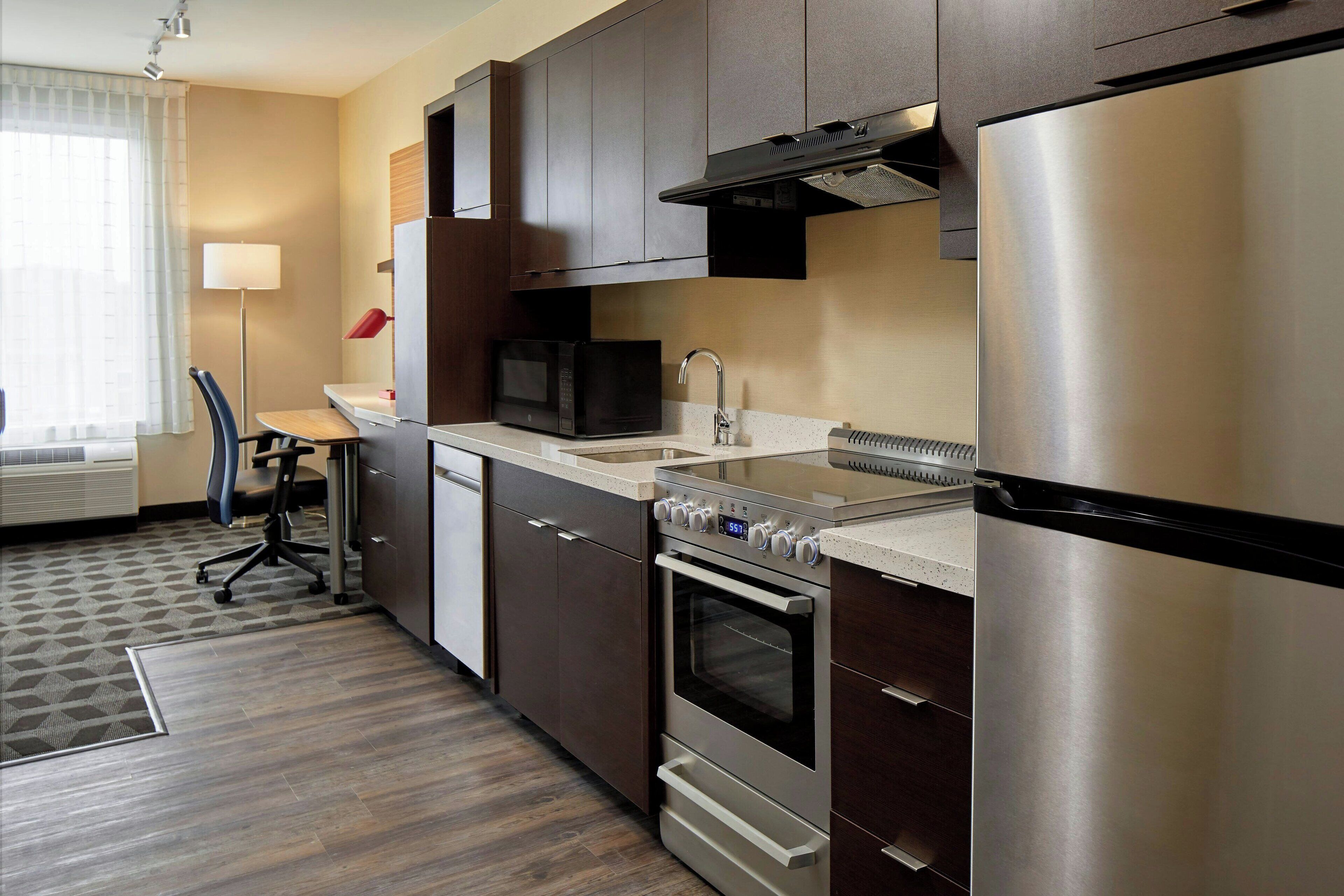 A compact kitchen with a microwave, stove, and refrigerator.