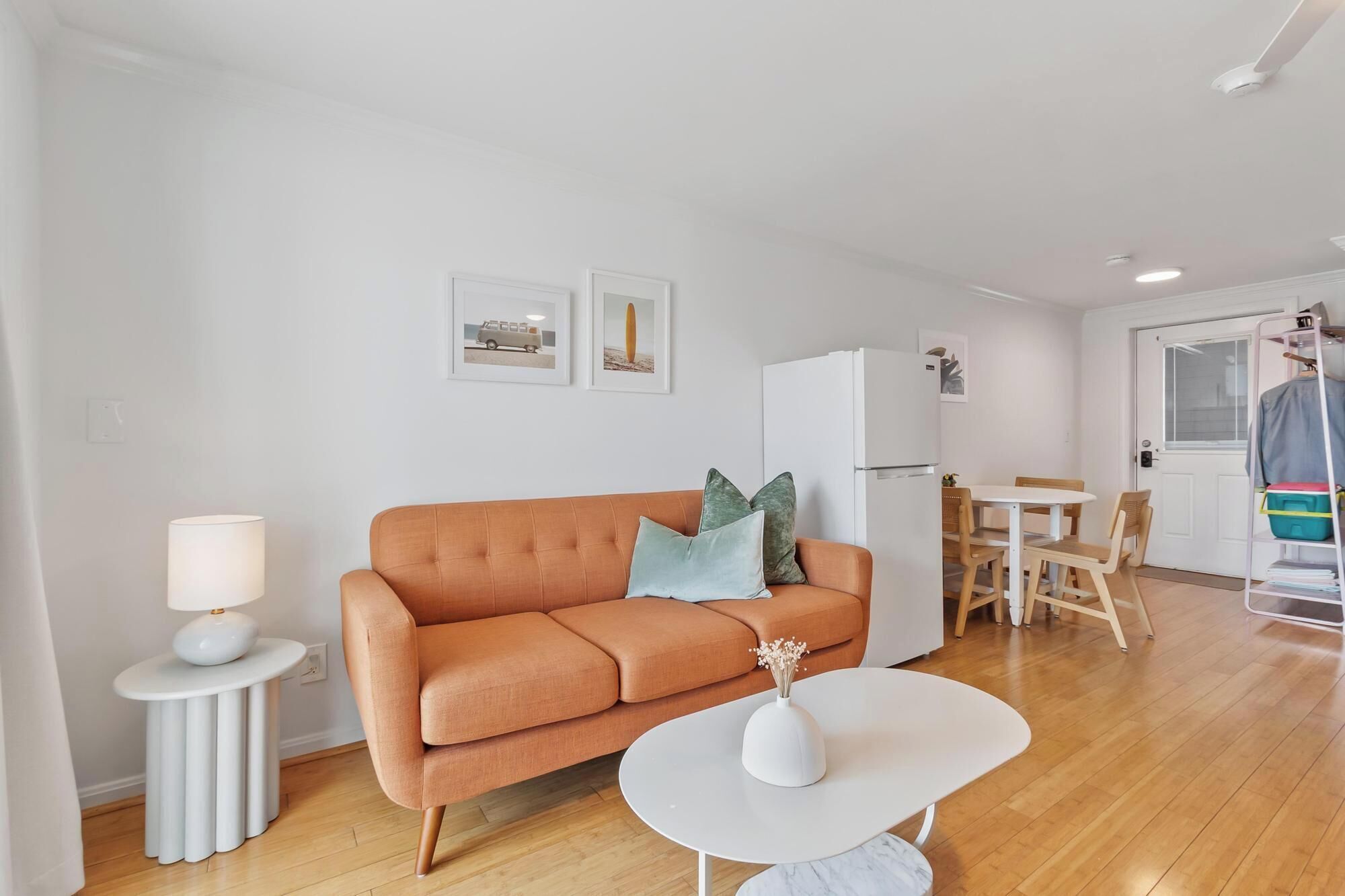 Ein modernes Wohnzimmer mit einer Couch, einem kleinen Tisch und einem Essbereich mit Stühlen.