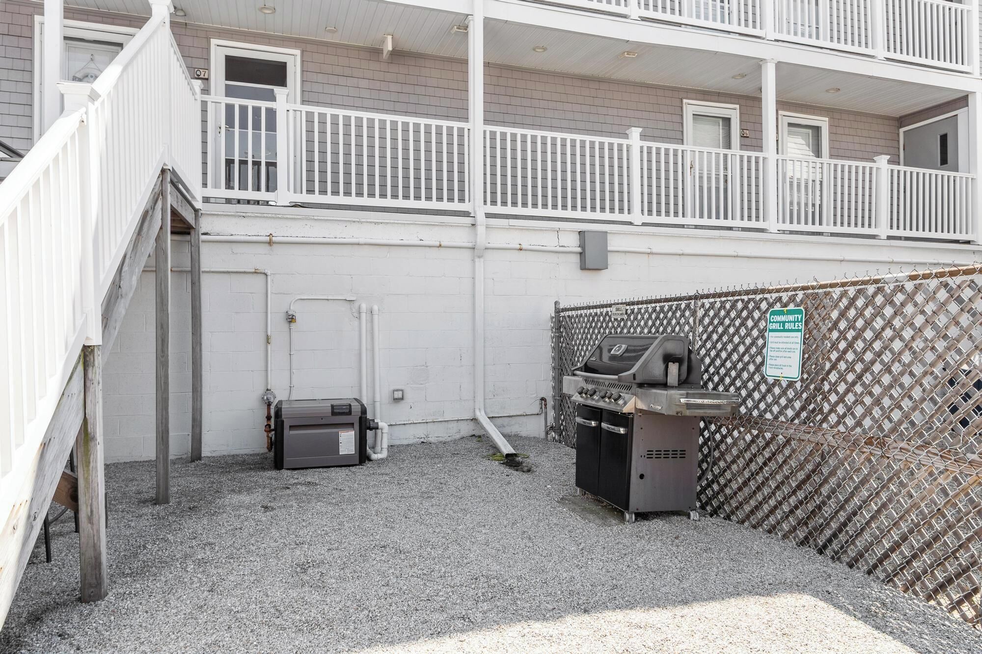 A fenced outdoor area with a grill and a water heater.