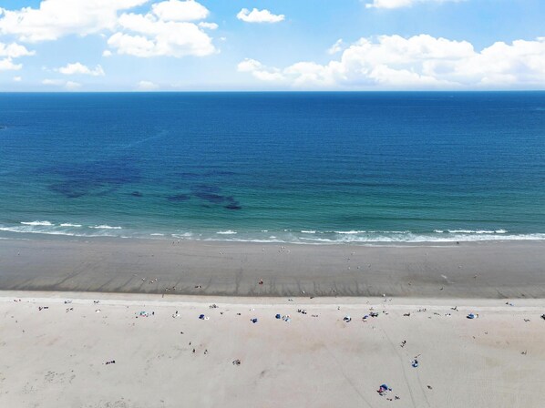 A beach with a clear view of the ocean and a sandy shore.
