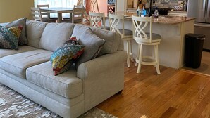Un salon moderne avec un canapé, des fauteuils et un coin repas.