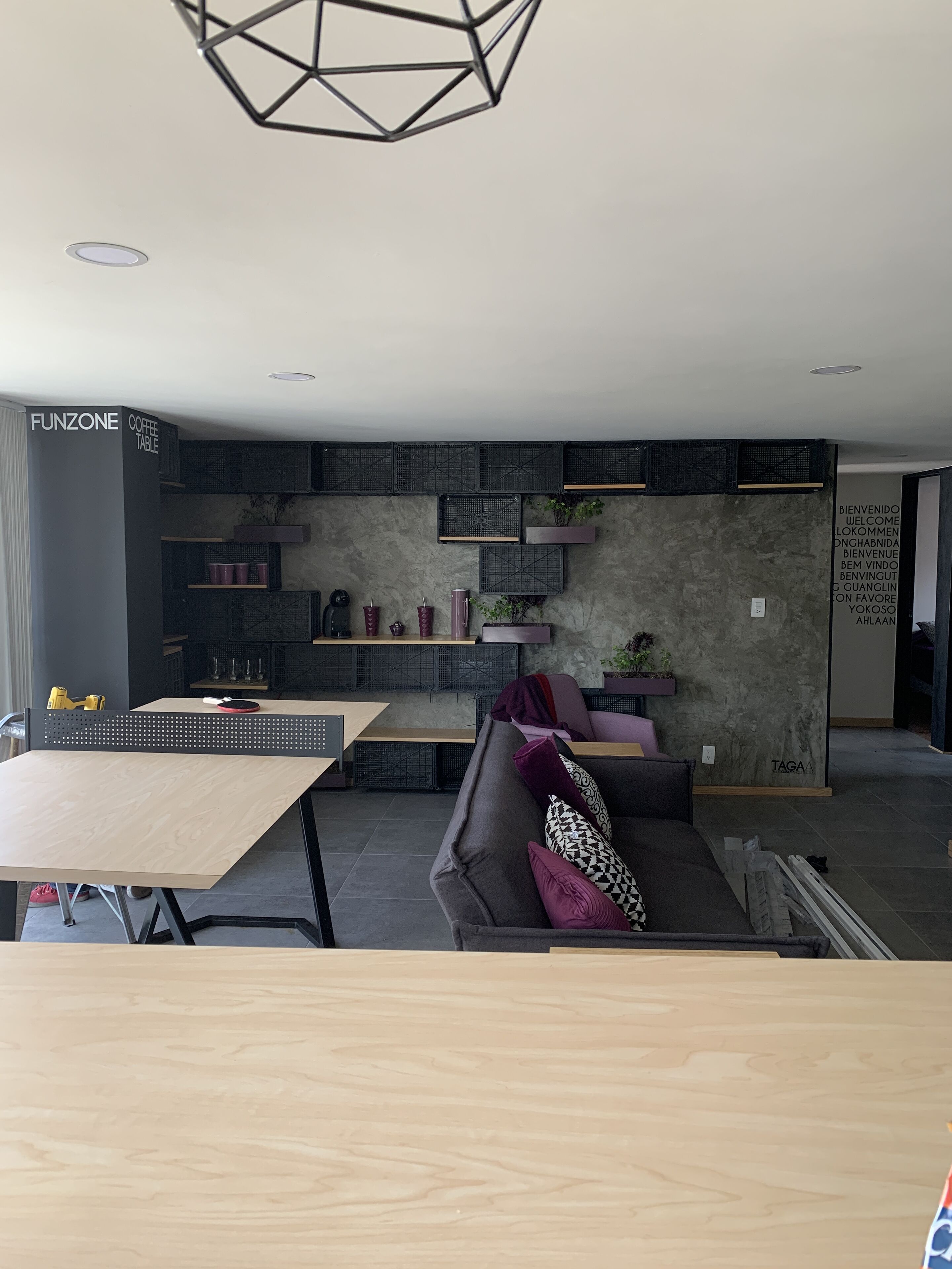 Un intérieur moderne avec un canapé, une table basse et des étagères remplies de divers objets.