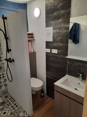 Een douche, handdoeken, zeep, toiletpapier