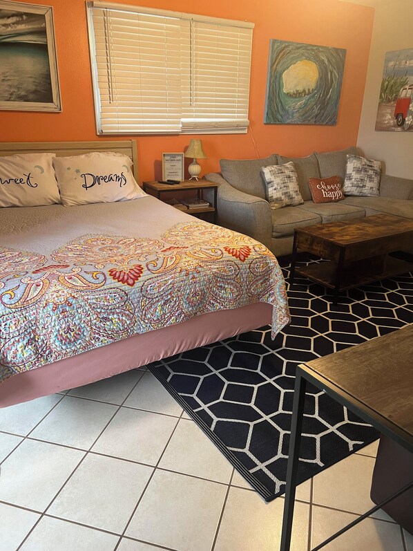 Une chambre à coucher avec un lit, un canapé, une table basse et un tapis.