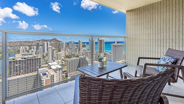 A balcony with a view of a cityscape and ocean.