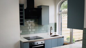 A compact kitchen with a built-in oven, a sink, and a window providing a view of the outside. - Modern 1-Bed Apartment in Chapel Allerton – Great for Longer Stays & Remote Work (Chapel Allerton)