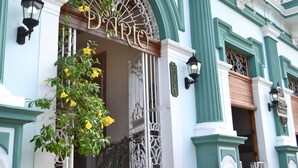 Fachada de edificio con una entrada arqueada destacada que dice "DANRIO", flanqueada por columnas verdes y ornamentación metálica.