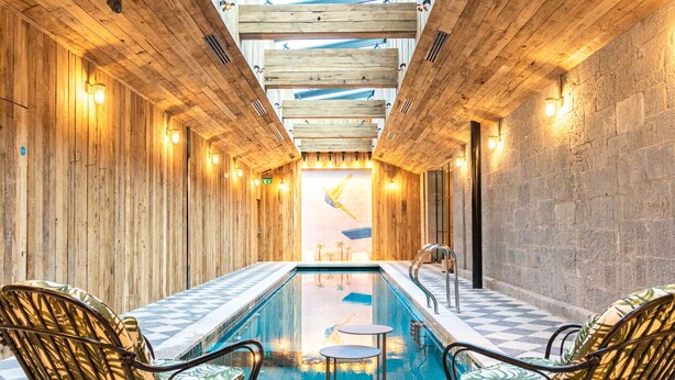 A pool area with wooden walls, two lounge chairs, and a checkered floor. - The Dean Cork (Cork)