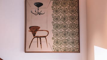 A modern interior with a staircase, a patterned wall, and a minimalist chair.