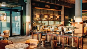 A bar area with wooden furniture, a marble countertop, and a large shelf with bottles. - The Dean Cork (Cork)