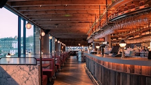 A bar area with a wooden ceiling, marble countertop, and red chairs. - The Dean Cork (Cork)