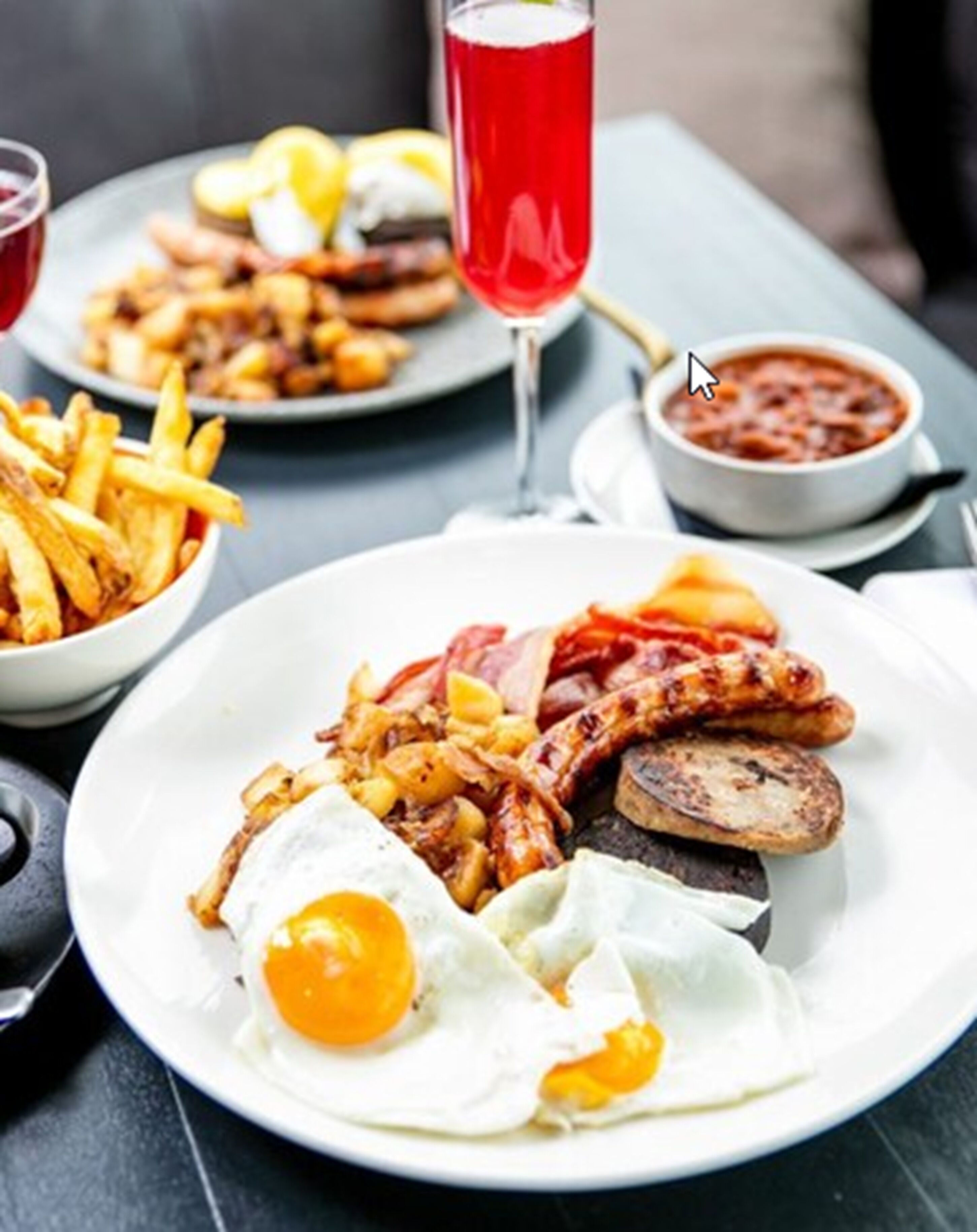Un plato con huevos, salchichas y papas fritas sobre una mesa.