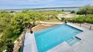 A swimming pool with a view of a lake and trees. - The Oasis at Canyon Lake - Gorgeous & Modern Waterfront Home + Pool + Sweeping Lake Views (Canyon Lake)