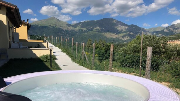 A hot tub with a view of mountains and a pathway leading to a building. - Albergo Diffuso Amatrice (Amatrice)