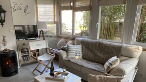 Ein gemütliches Wohnzimmer mit einer Couch, einem Couchtisch, einem Fernseher und einem Kamin.
