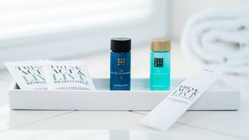A white box containing two bottles and a booklet. One bottle is labeled "The Ritual of Hamma" conditioner, and the other is labeled "The Ritual of Karma" body lotion. A booklet titled "Think Act Live" is also visible.