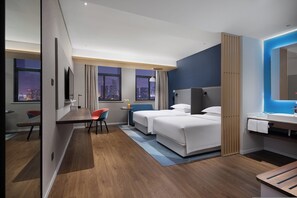 A hotel room with a bed, a desk, a chair, a small table, a nightstand, a mirror, and a view of the city at night. - Holiday Inn Express Changsha South Railway Station by IHG (Changsha)