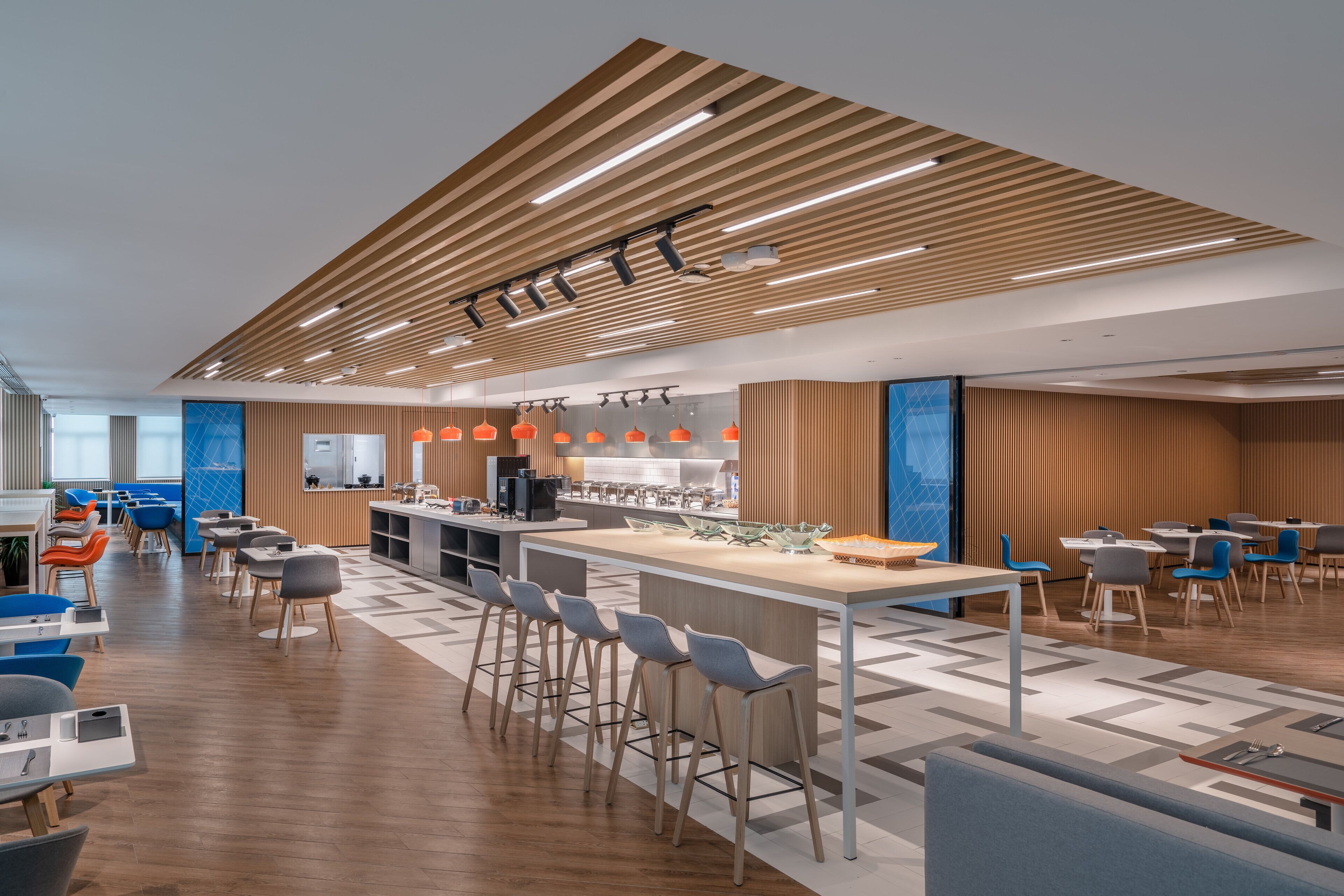 Un restaurante moderno con techo de madera, asientos de bar y zona de bufé.