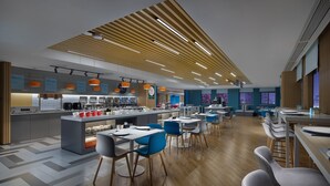 A modern restaurant with a central island, blue and gray chairs, and a wooden ceiling. - Holiday Inn Express Changsha South Railway Station by IHG (Changsha)