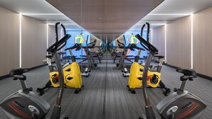 Ein Fitnessraum mit mehreren Ergometer und Laufbändern, die in einer spiegelbildlichen Anordnung angeordnet sind.
