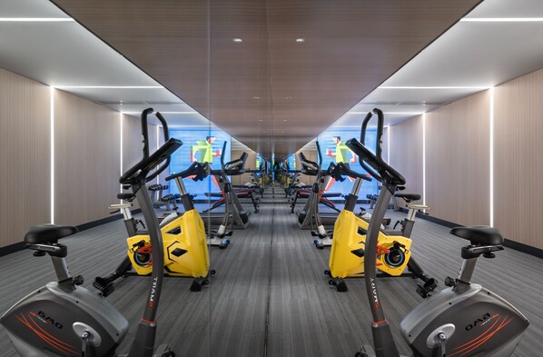 A gym with multiple exercise bikes and treadmills, arranged in a mirrored layout. - Holiday Inn Express Changsha South Railway Station by IHG (Changsha)