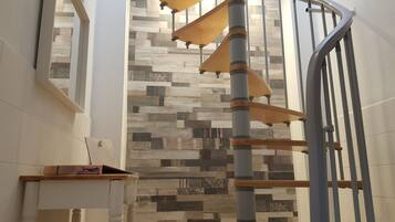 Un escalier au design moderne, doté d’une main courante en bois et d’une rampe en métal.