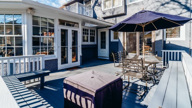 A covered patio with outdoor furniture, a large umbrella, and a view of the house. - Only Urban Beach House in Chicago (Chicago)