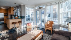 A spacious kitchen with wooden cabinets, a bar stool, and a dining area with a table and chairs. - Only Urban Beach House in Chicago (Chicago)