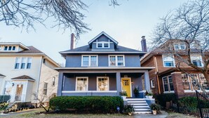 A two-story house with a front porch, a yellow door, and a brick chimney. - Only Urban Beach House in Chicago (Chicago)