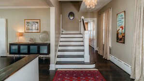 A staircase with a wooden handrail and a red patterned rug leading to a landing. - Only Urban Beach House in Chicago (Chicago)