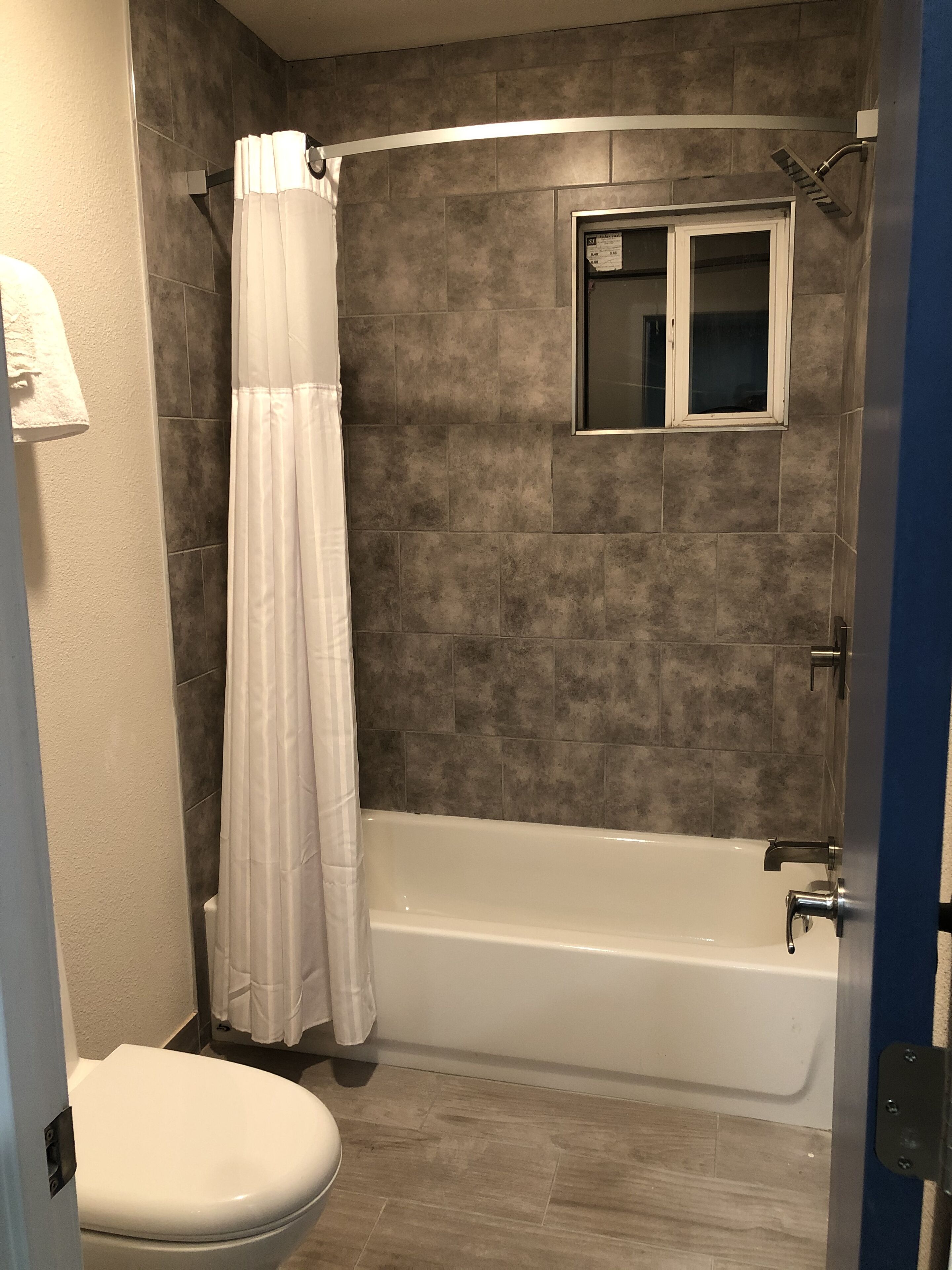 A bathroom with a bathtub, a toilet, and a shower curtain.