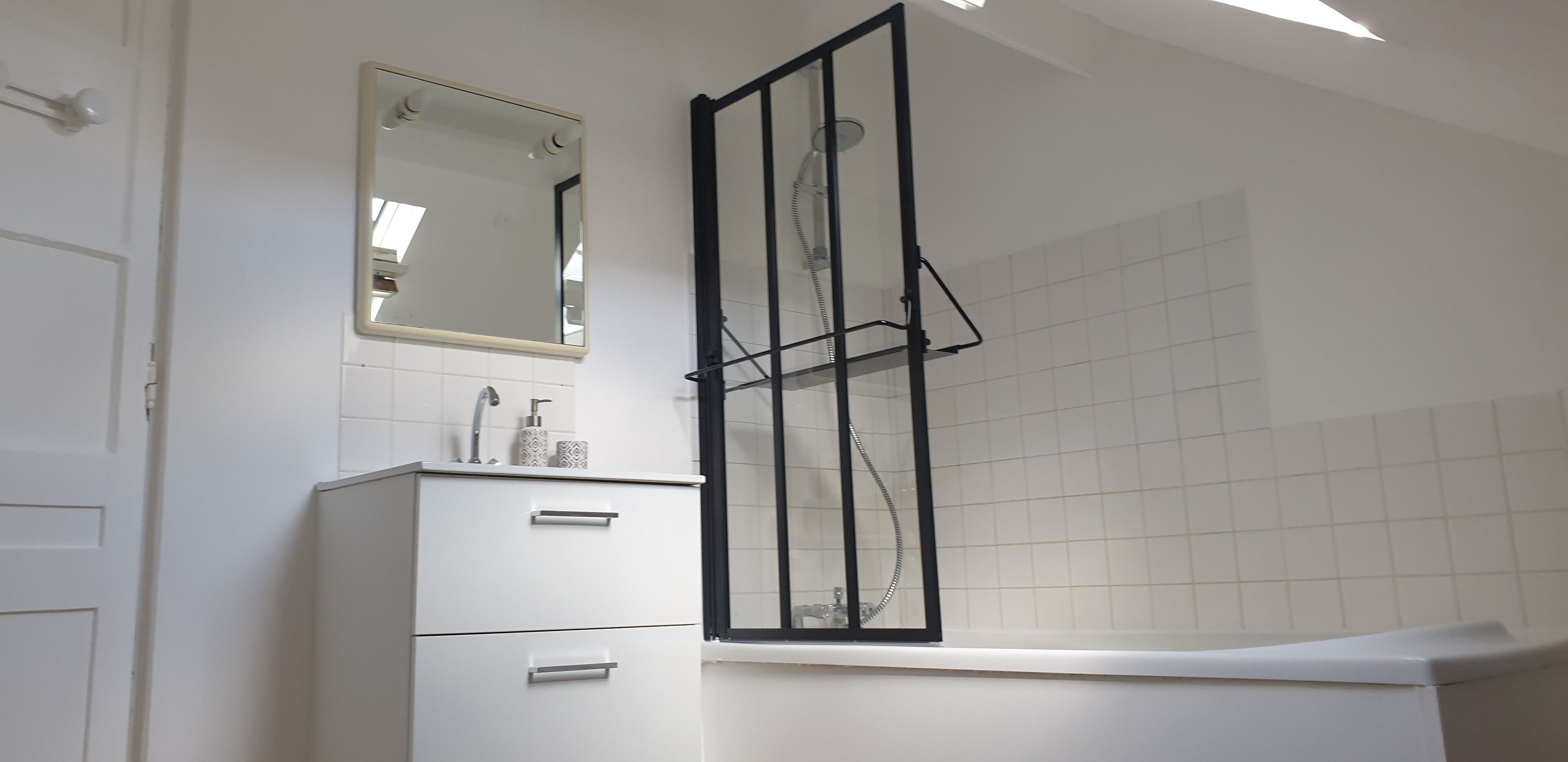 Een bad/douchecombinatie, een haardroger, handdoeken, toiletpapier