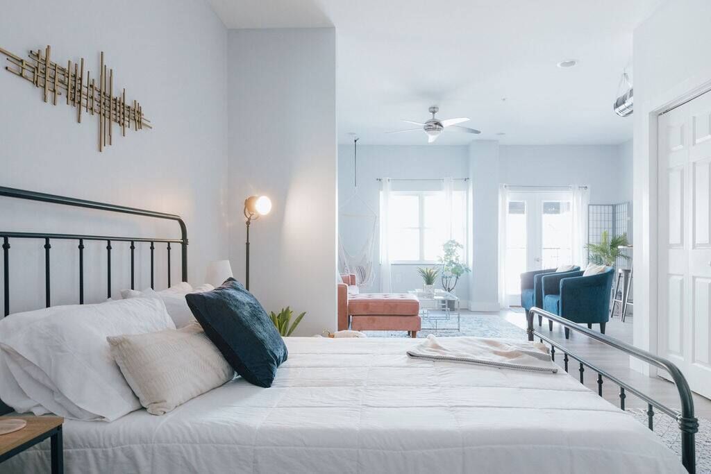 A bedroom with a bed, bedside table, and a ceiling fan.
