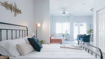 A bedroom with a bed, bedside table, and a ceiling fan.