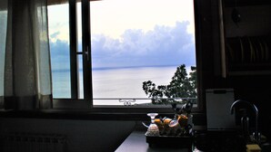 Eine Küche mit Blick auf das Meer durch ein Fenster.