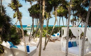 Ein Strandresort mit weißen Cabanas, Hängematten und einem Poolbereich.
